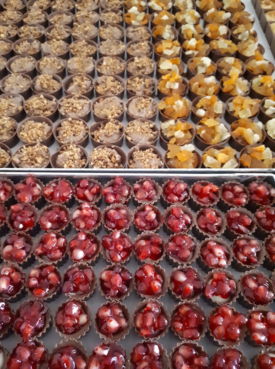 Assorted Belgian chocolate cups with nuts, candied fruit and pomegranate